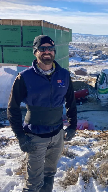 Man in winter construction site, wearing beanie