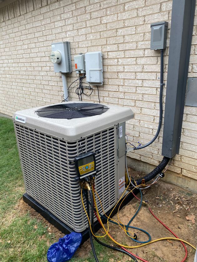 Gray air conditioning unit with a fan and vertical metal fins.
