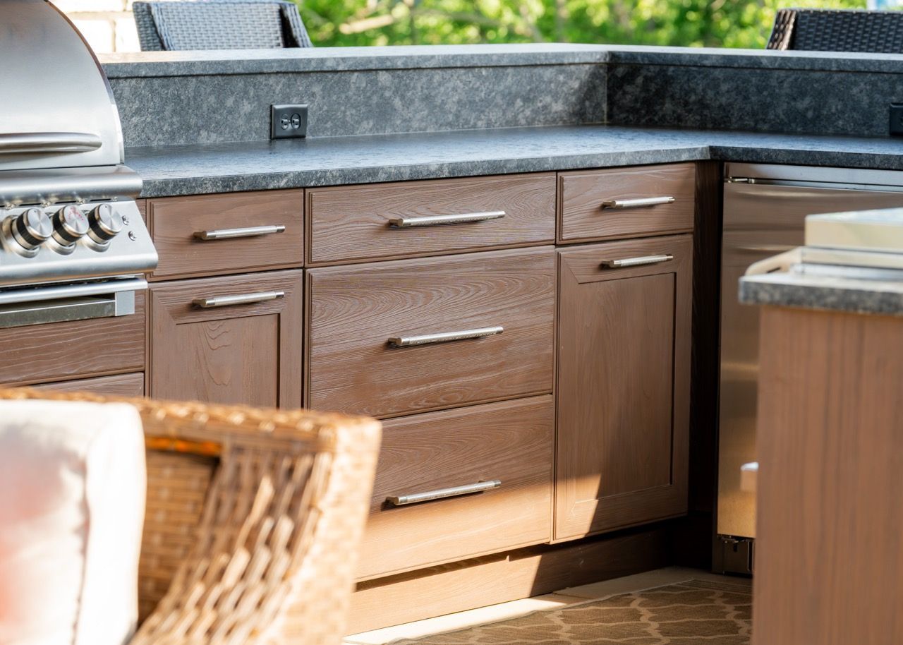 A large outdoor kitchen with stainless steel appliances and a grill.