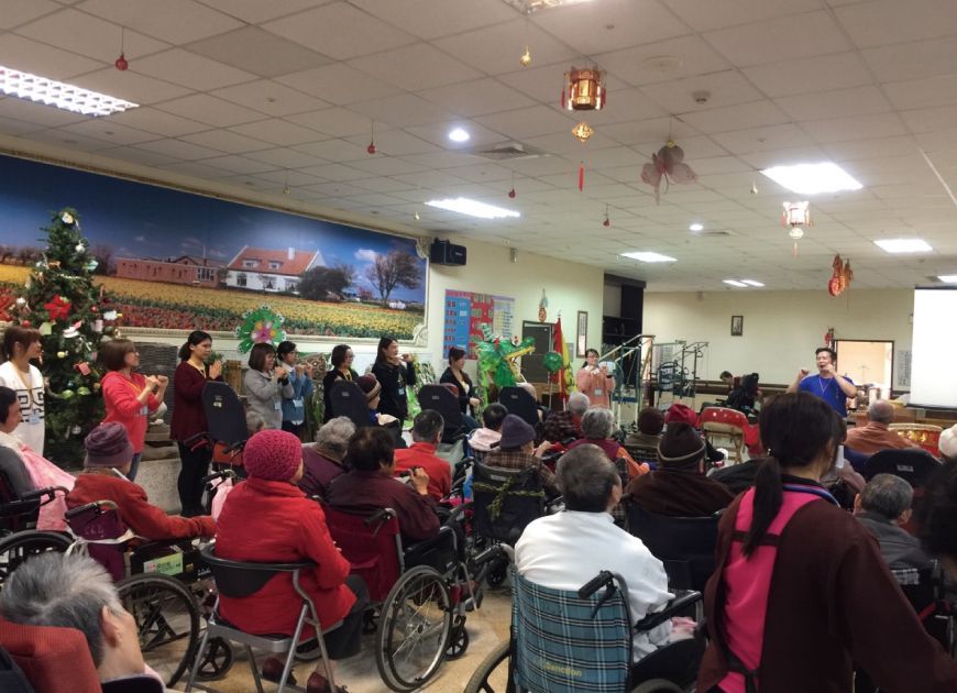 聖力團隊與坐輪椅長輩在裝飾房間參加團體關懷活動，落實人性化照護與社會關懷精神。