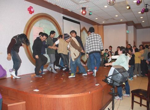 聖力國際舉辦的外籍勞工節慶聯誼活動，移工在裝飾燈光與氣球的舞台上愉快跳舞休息。