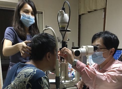 協助外勞醫療就醫與定期體檢，眼科醫師使用裂隙燈儀器檢查移工眼睛健康狀況。