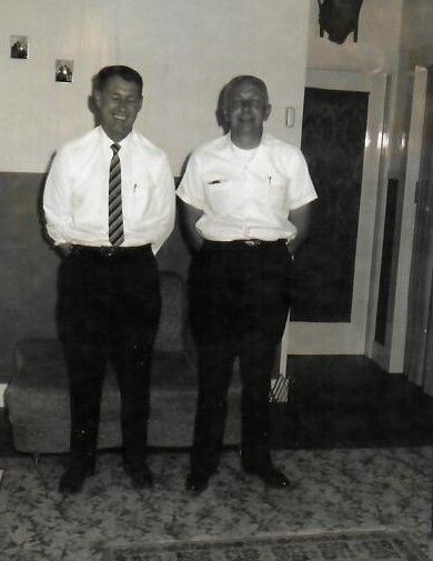 two men are standing next to each other in a living room .