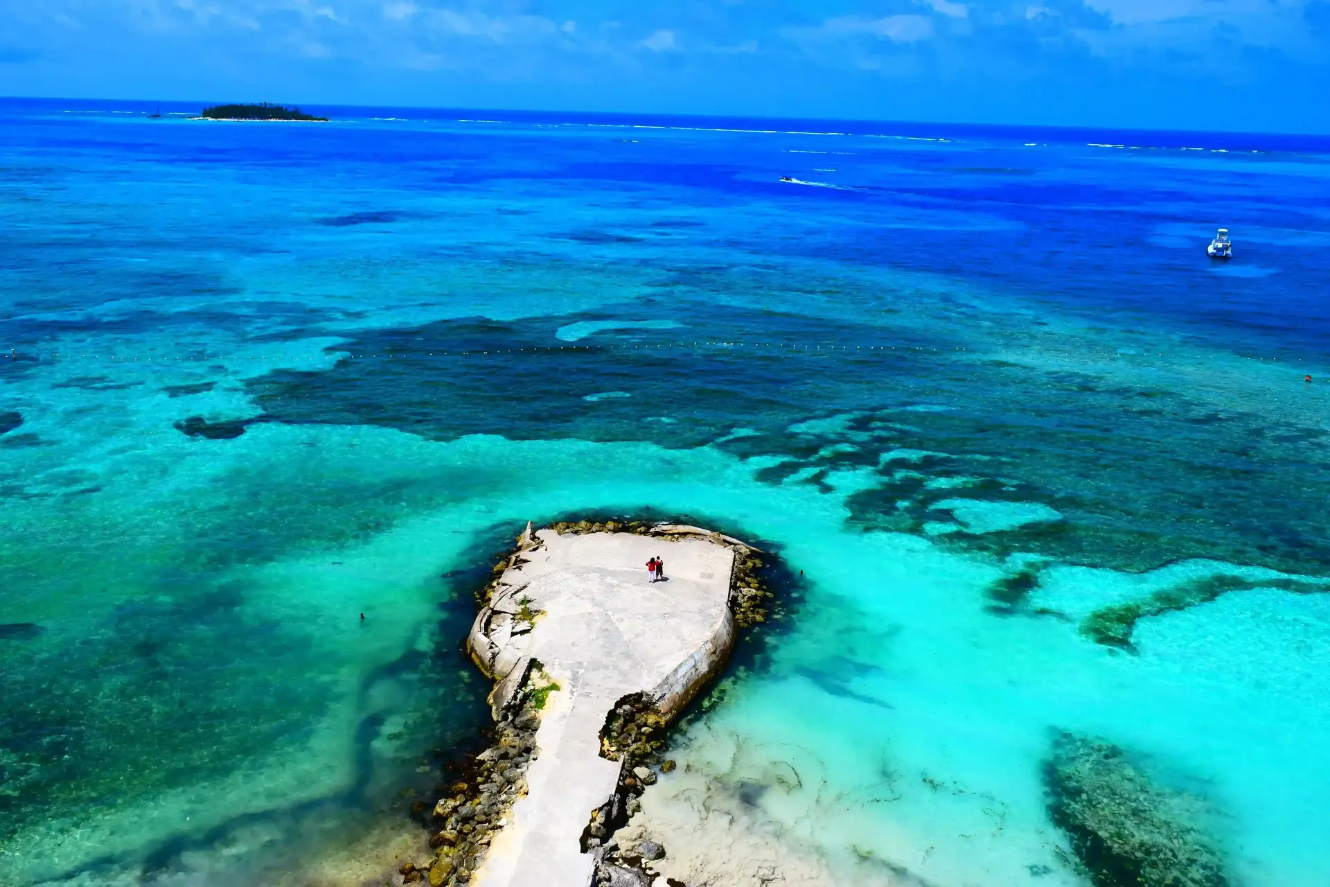Vista aérea de San Andrés Islas con mar de siete colores y turistas disfrutando del paisaje caribeño.
