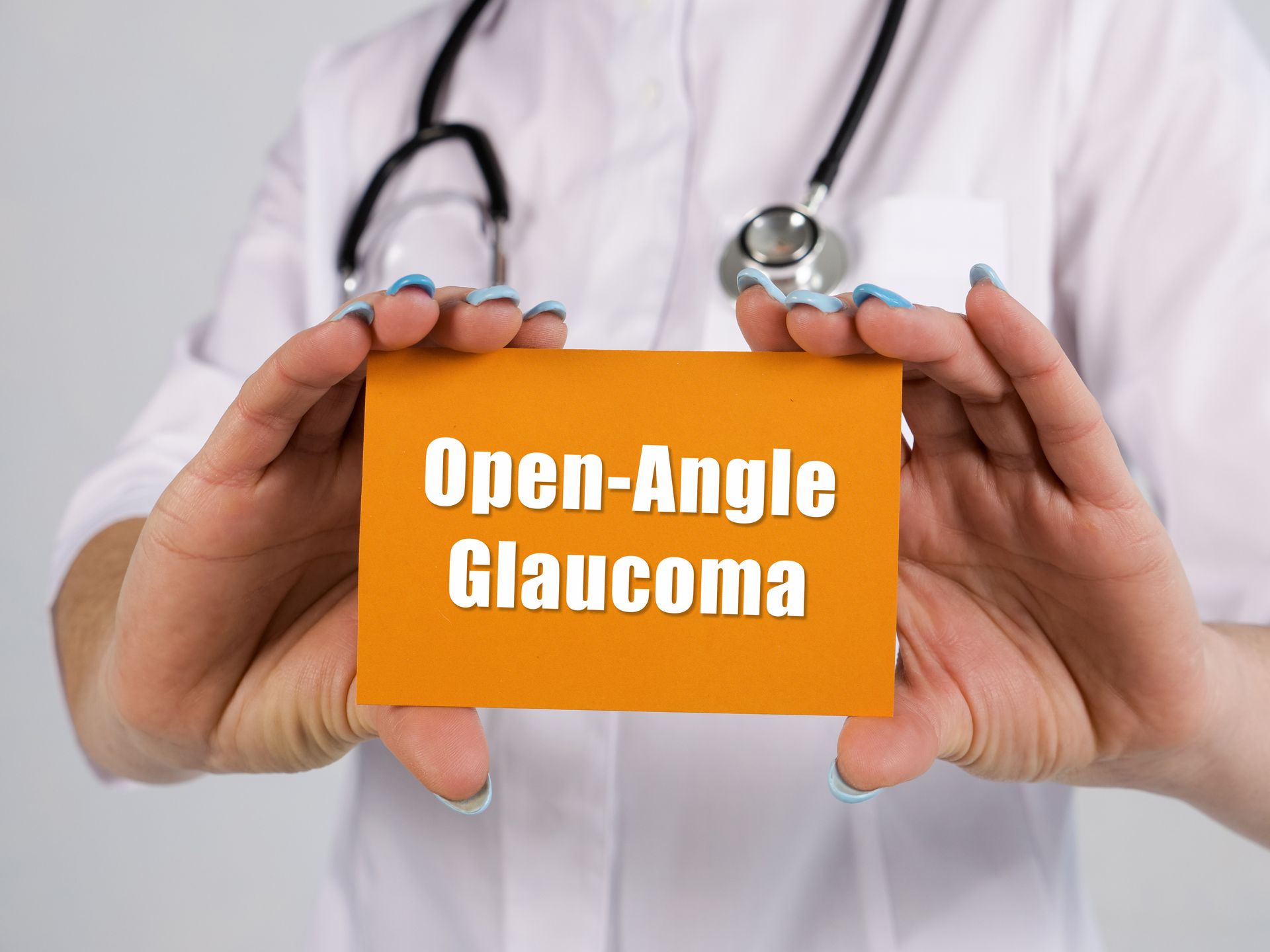 A doctor is holding a card with the words `` open angle glaucoma '' written on it.