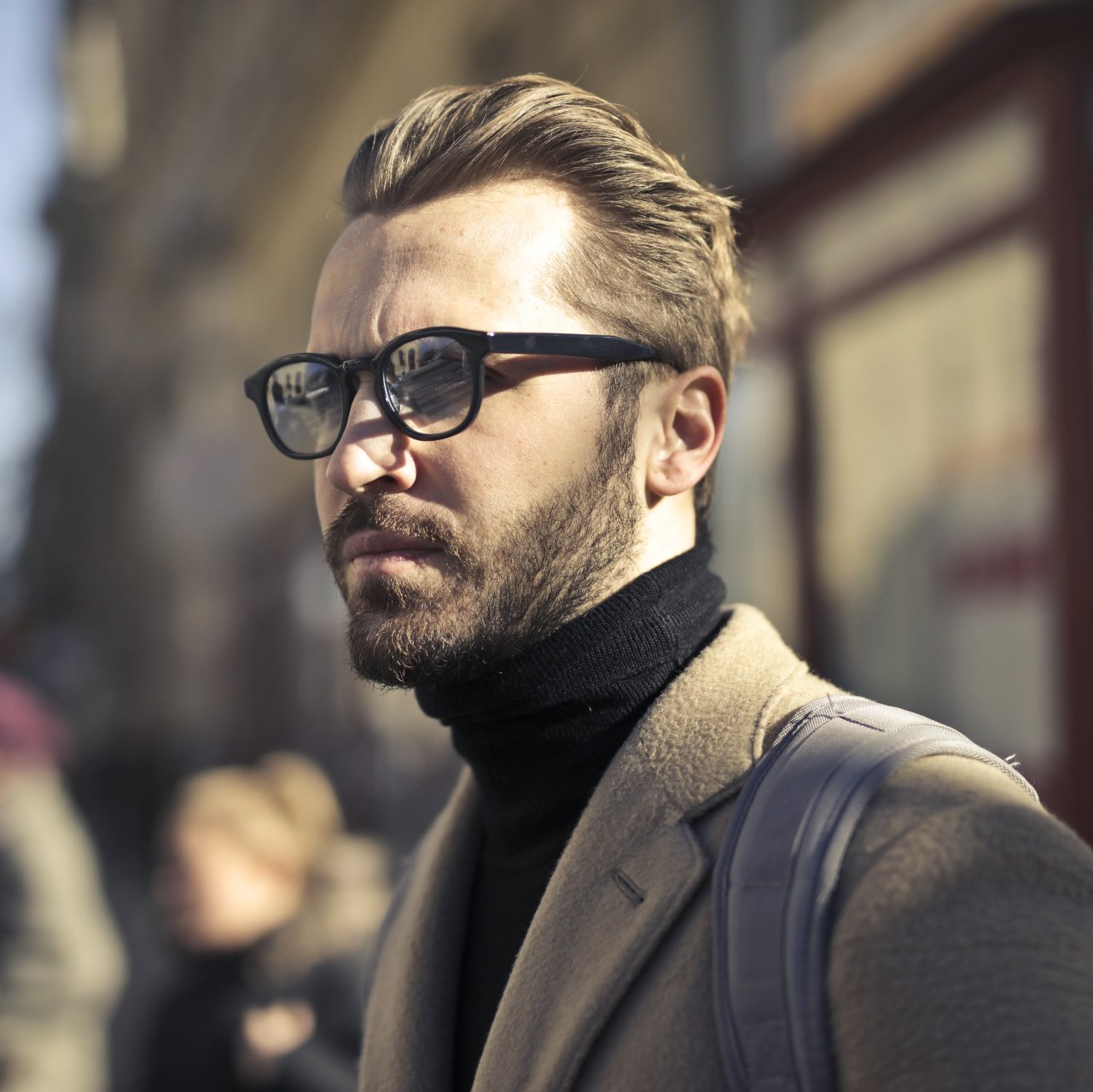A man with a beard wearing glasses and a turtleneck