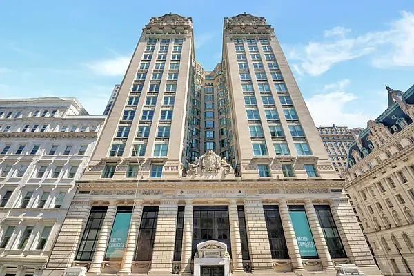 Tall historic building with twin towers and a stone facade under a blue sky