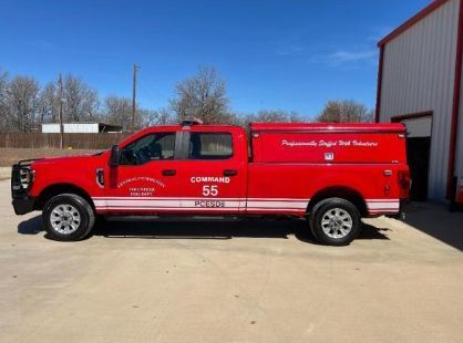 Red fire rescue truck parked outdoors in front of a building under a clear blue sky
