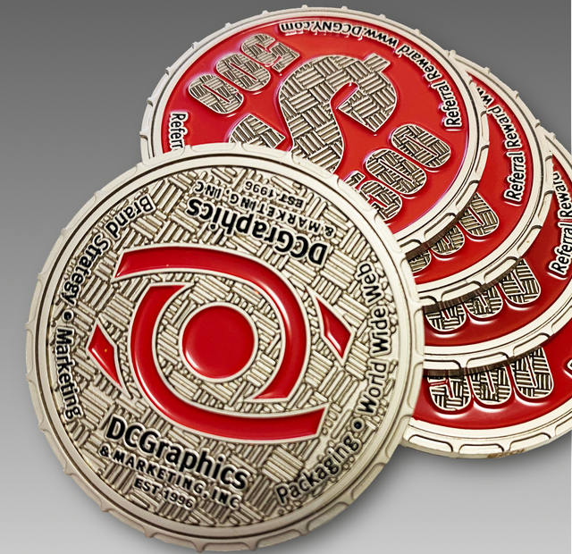 Silver and red DC Graphics coins, with company logo and text, stacked.