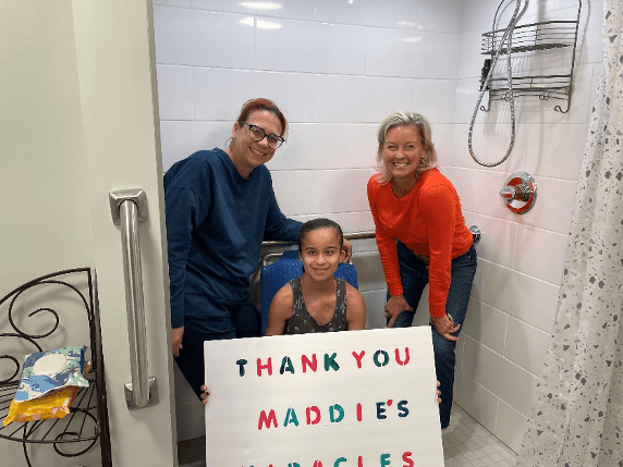 Three people in a new bathroom. Girl holds