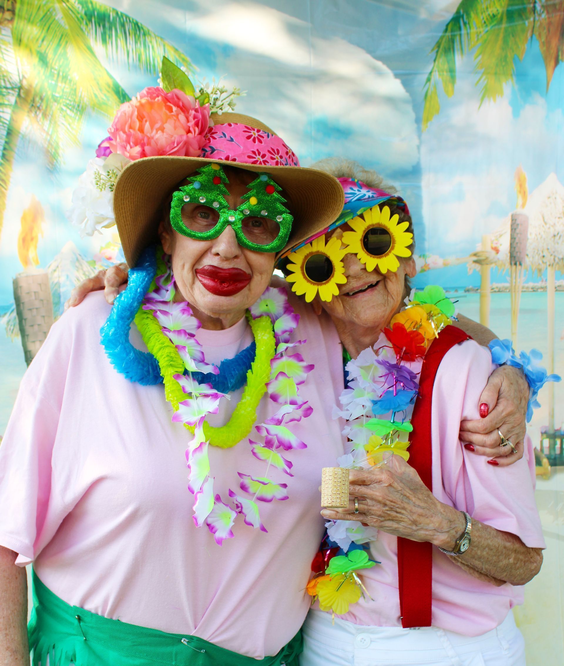 Two women are posing for a picture and one is wearing a hat and sunglasses