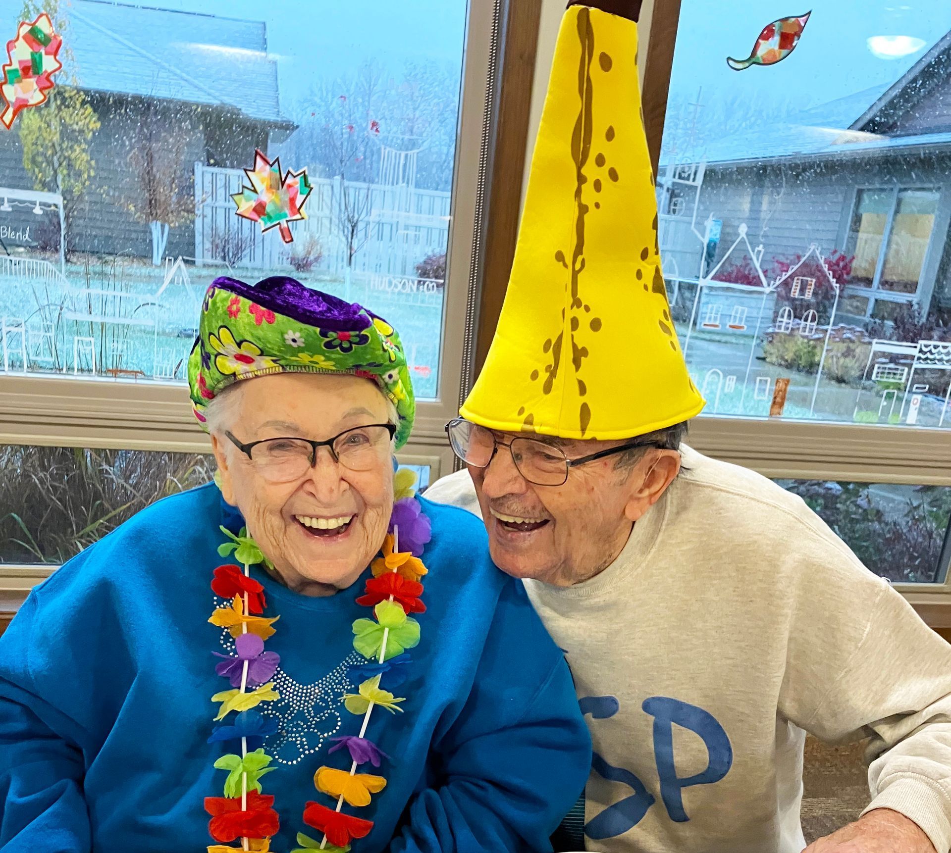 A man wearing a yellow hat and a woman wearing a blue sweater with the letter sp on it