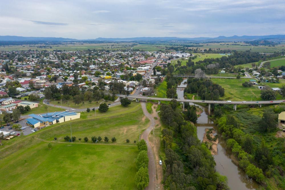 An Aerial View Of A Small Town Next To A River And A Bridge — Tim's Towing and Transport In Bulga, NSW