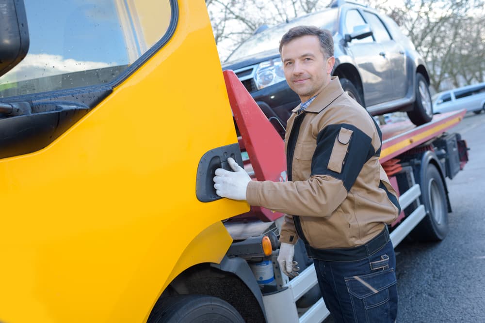 Tow Truck Driver With A Towed Car — Tim's Towing and Transport In Greta, NSW