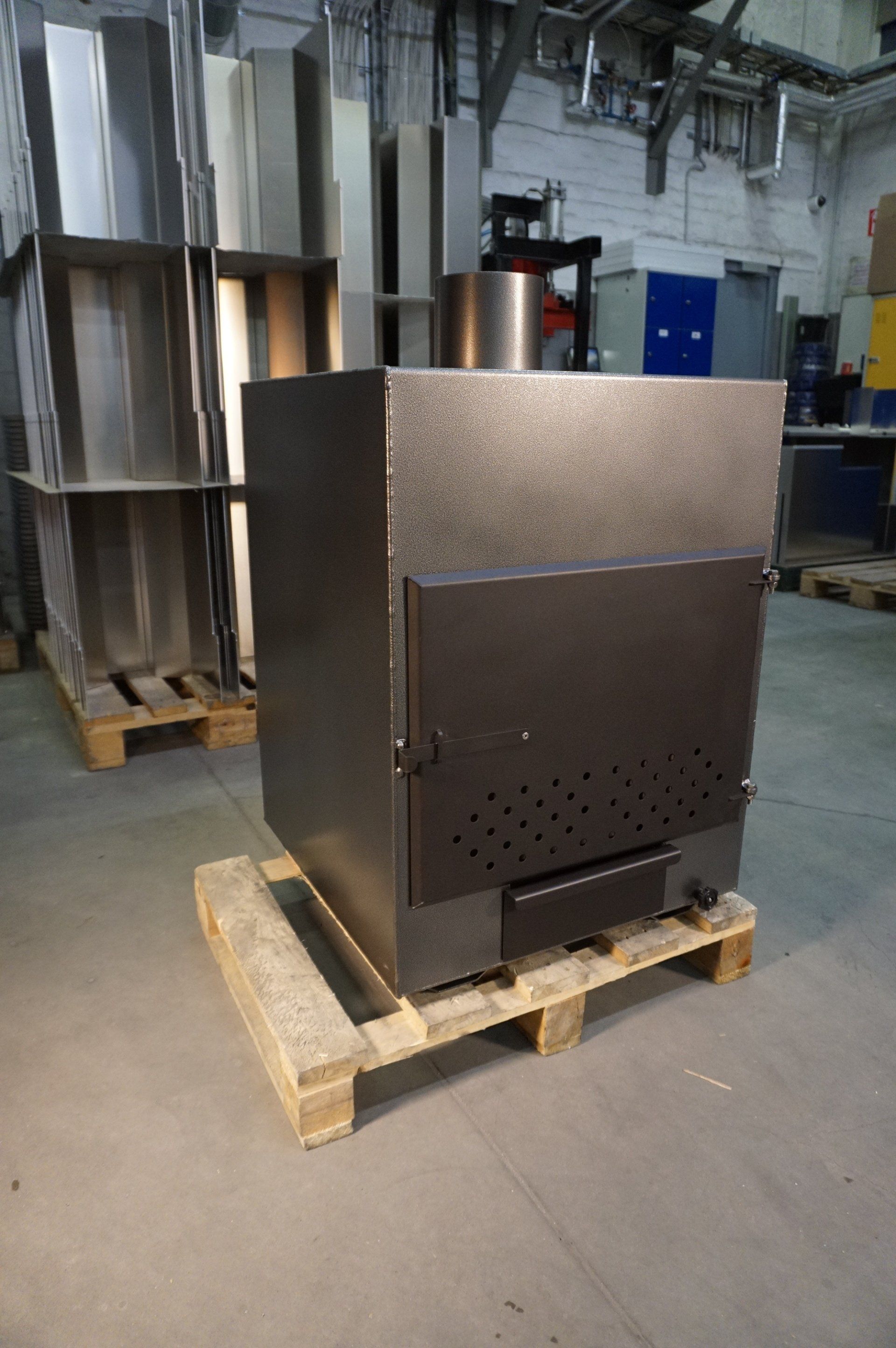 Industriskab i metal på en træpalle i et lager med et tekstureret mørkt frontpanel.