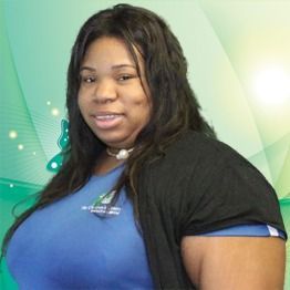 Woman in a blue shirt posing against a green gradient background.