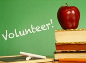 “Volunteer!” written on a chalkboard beside an apple on stacked books