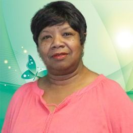 Woman in a pink blouse smiling against a soft green background with butterfly accents