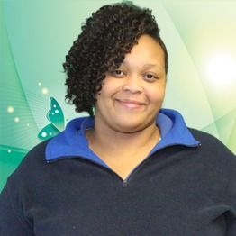 Smiling person in a dark sweater with a blue collar against a green background with butterfly accents