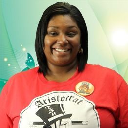 Smiling woman in a red T-shirt with a graphic logo on a green background