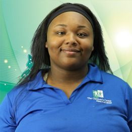 Woman in blue polo shirt smiling against a green gradient background