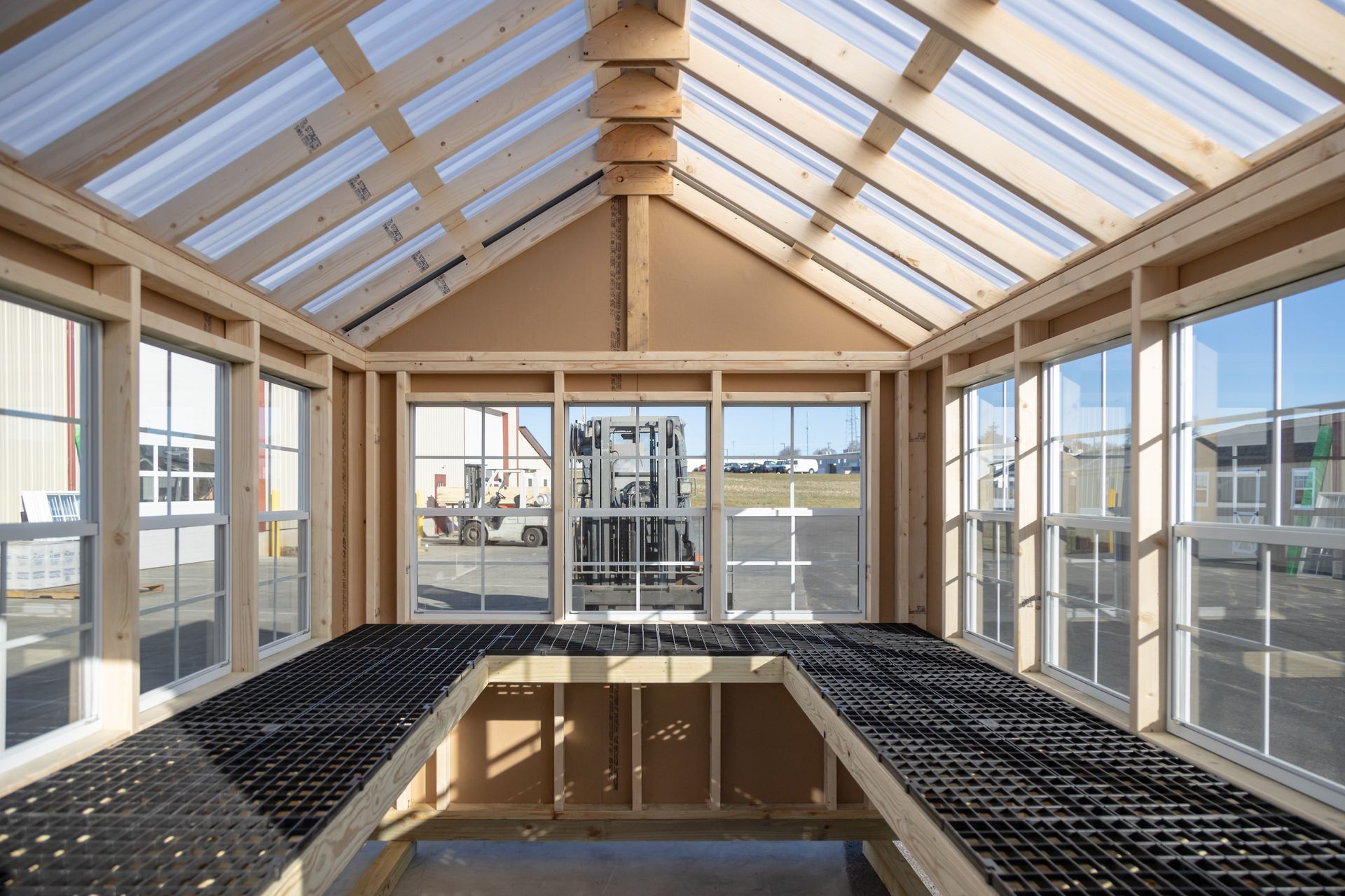An inside view of a shed with a lot of windows and a clear roof.