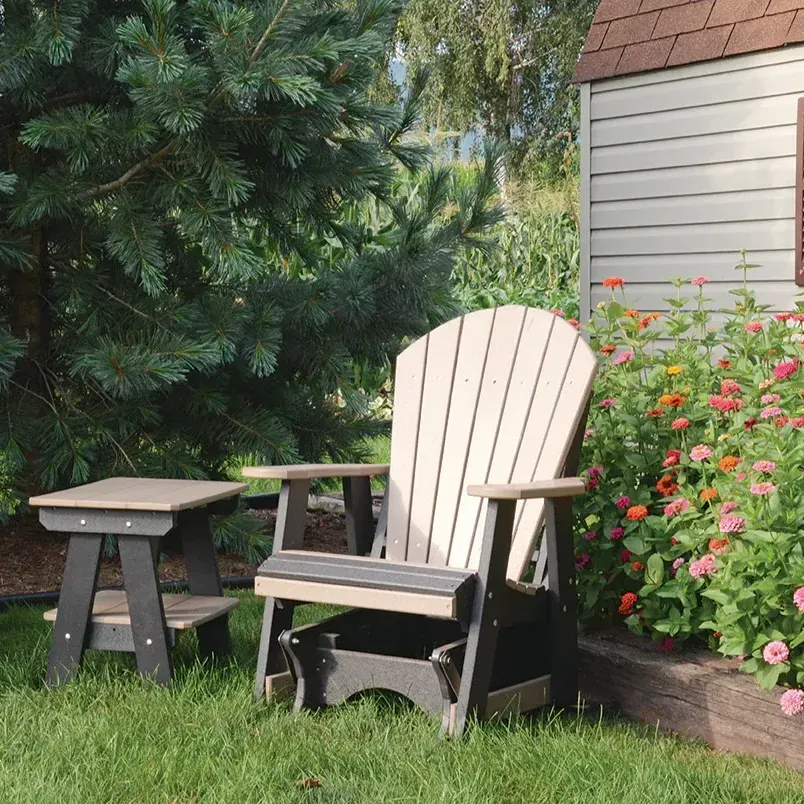 Brown adirondack chair an adirondack chair sits in the grass next to a table
