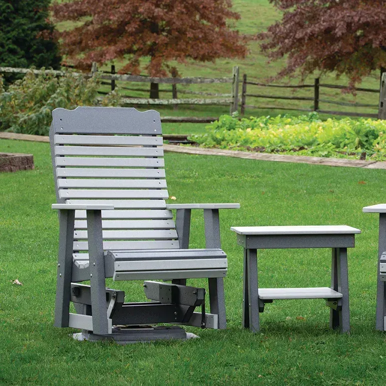 Gray adirondack chair & table Adirondack chair and table are sitting on top of a lush green lawn.