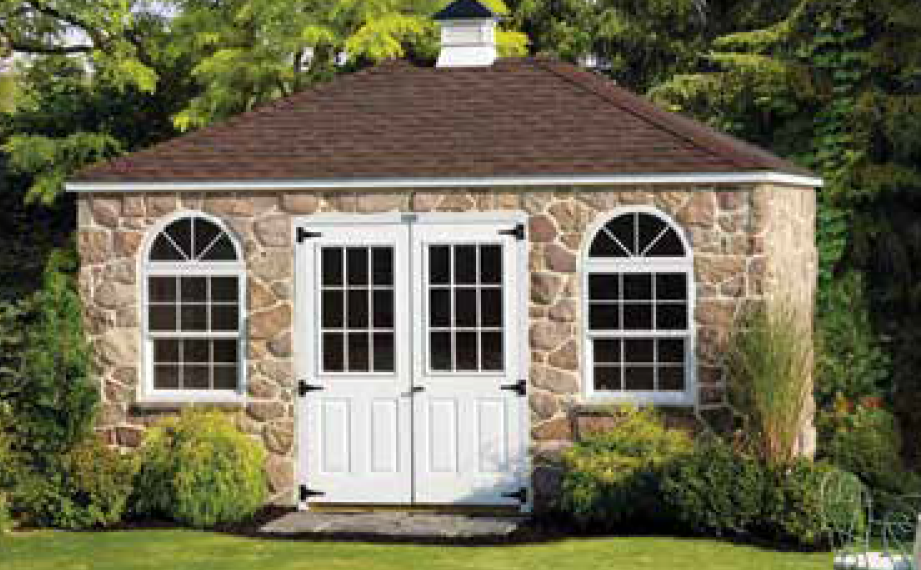 Shed with stone siding a shed with a weather vane on top of it