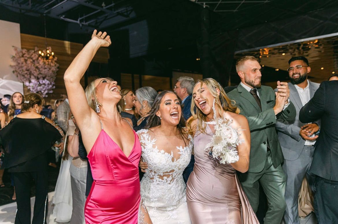 a group of people are dancing at a wedding reception .