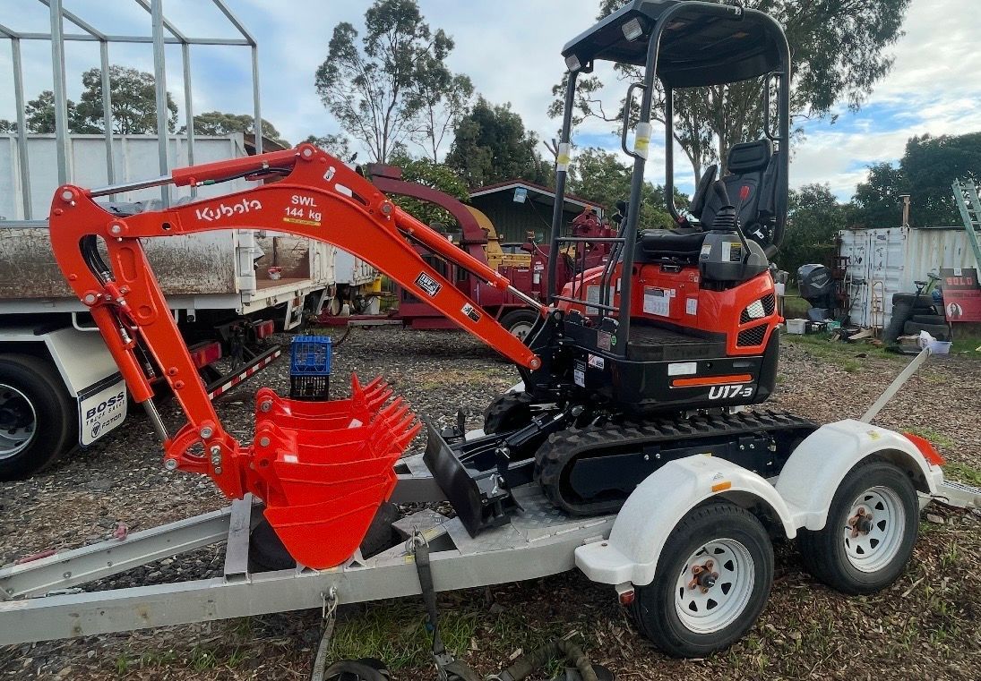 Red Compact Excavator on a White Dual-axle Trailer Outdoors — A Grade Tree Services in Burpengary, QLD