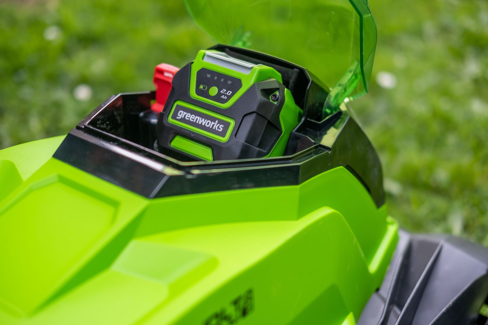 Photograph of a battery inserted into the battery compartment of a Greenworks' battery electric cordless mower.