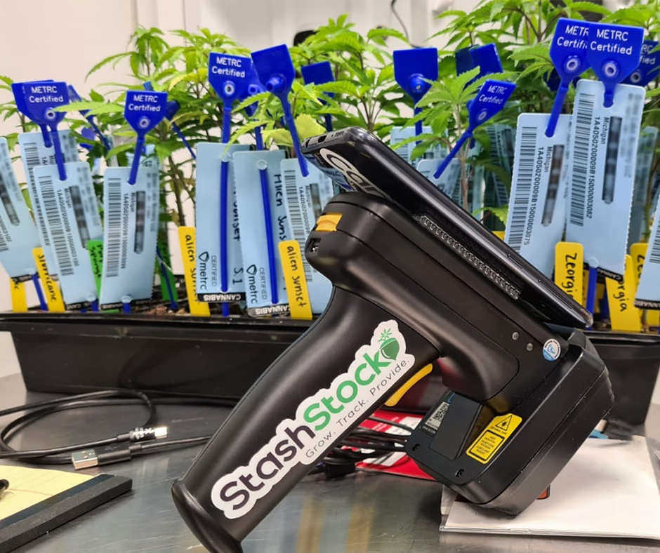 StashStock's CannaScanner in front of cannabis seedlings with METRC tags