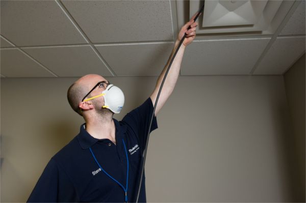 A man wearing a mask is looking up at the ceiling