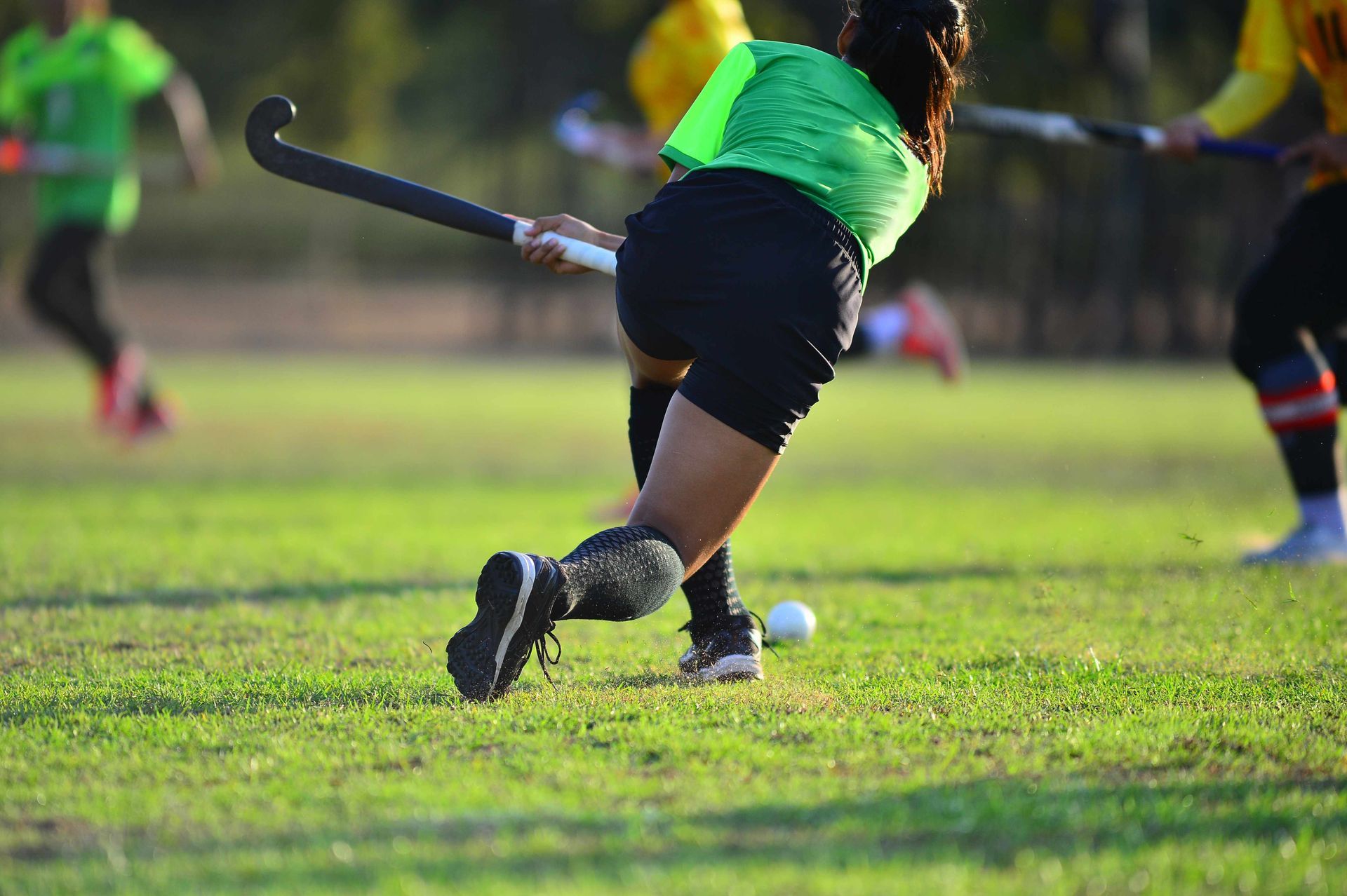 People playing lacrosse on an artificial grass field