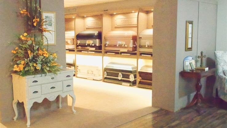 A room with a dresser and a table with flowers on it