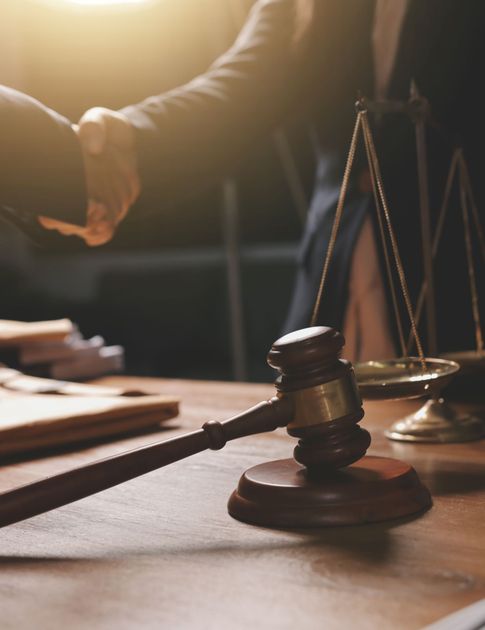 Judge’s gavel on a desk with scales of justice in a courtroom setting