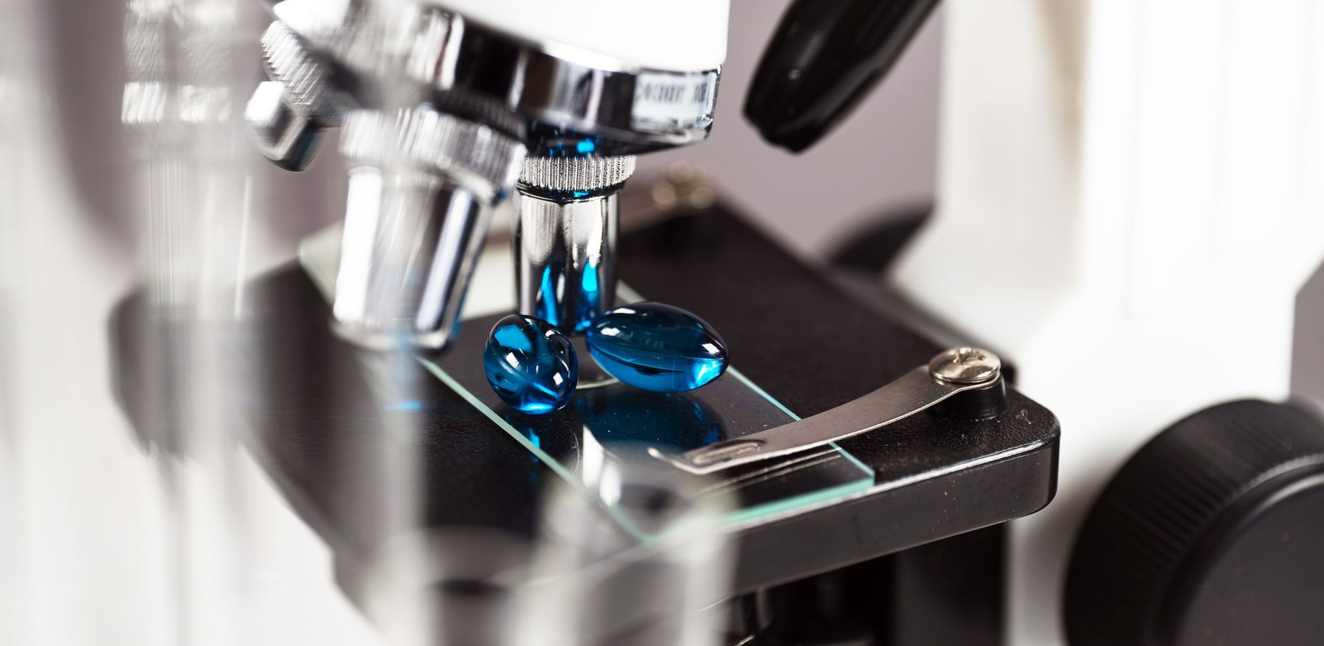A blue pill is being examined under a microscope.