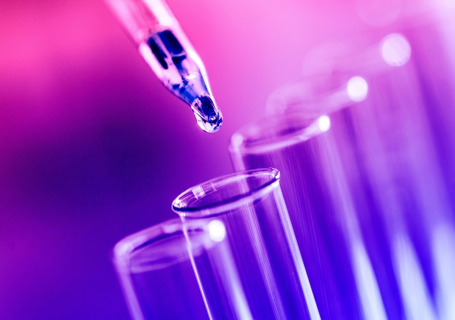 A drop of liquid is being poured into a test tube.