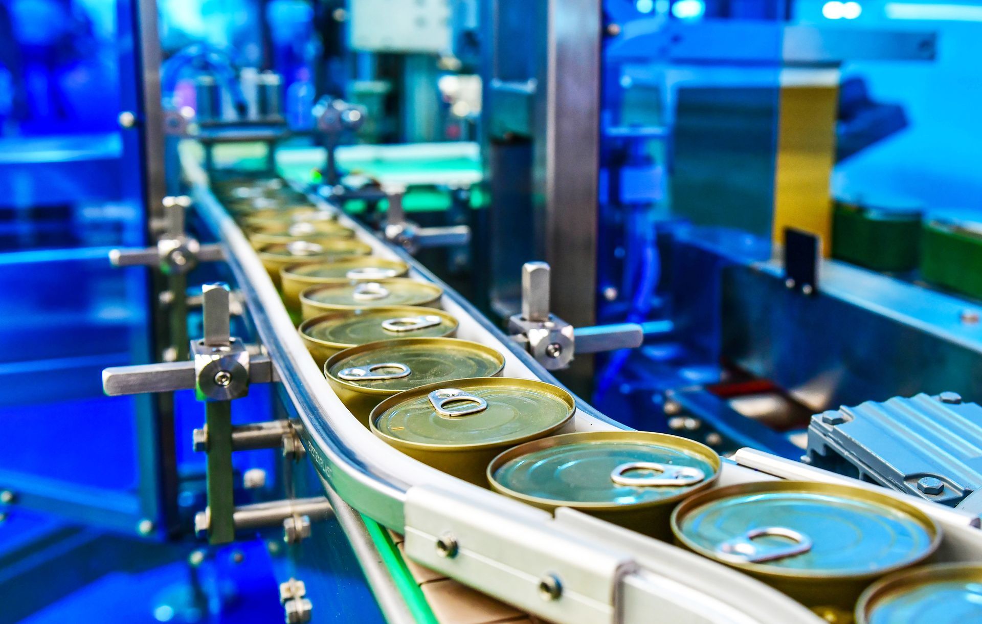 A conveyor belt filled with cans of food in a factory.