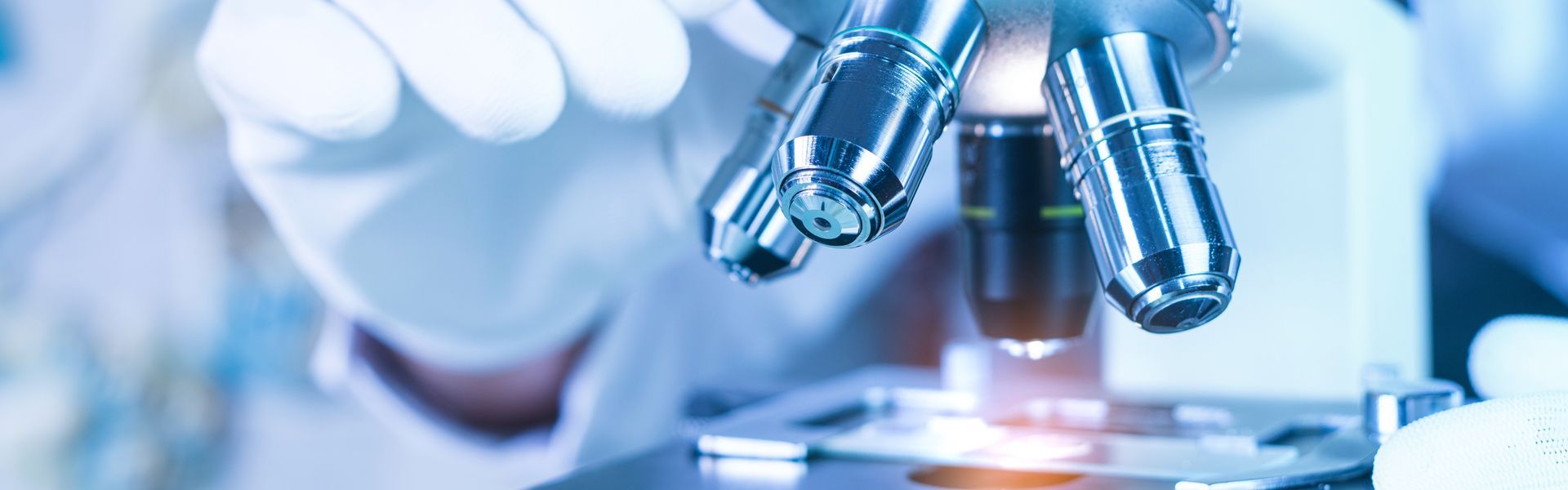 A person is looking through a microscope in a laboratory.