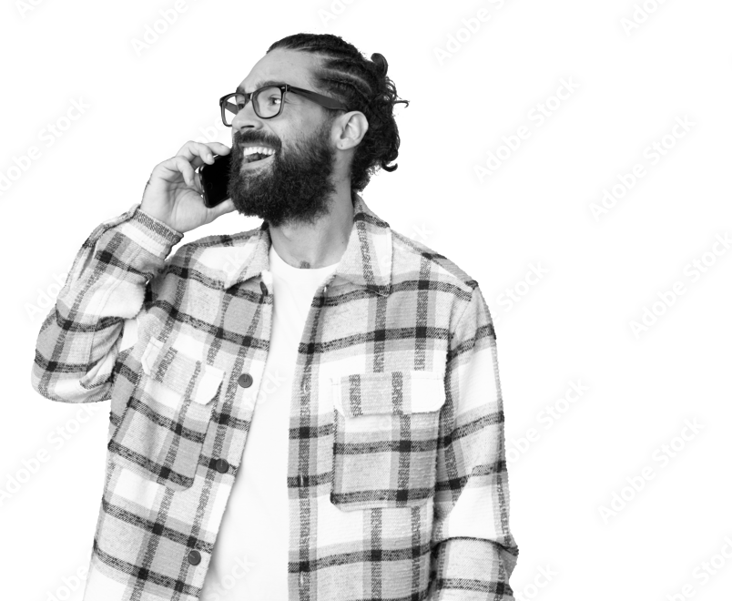 A man with a beard and glasses is talking on a cell phone.
