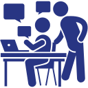 A man is standing next to a woman sitting at a desk with a laptop.
