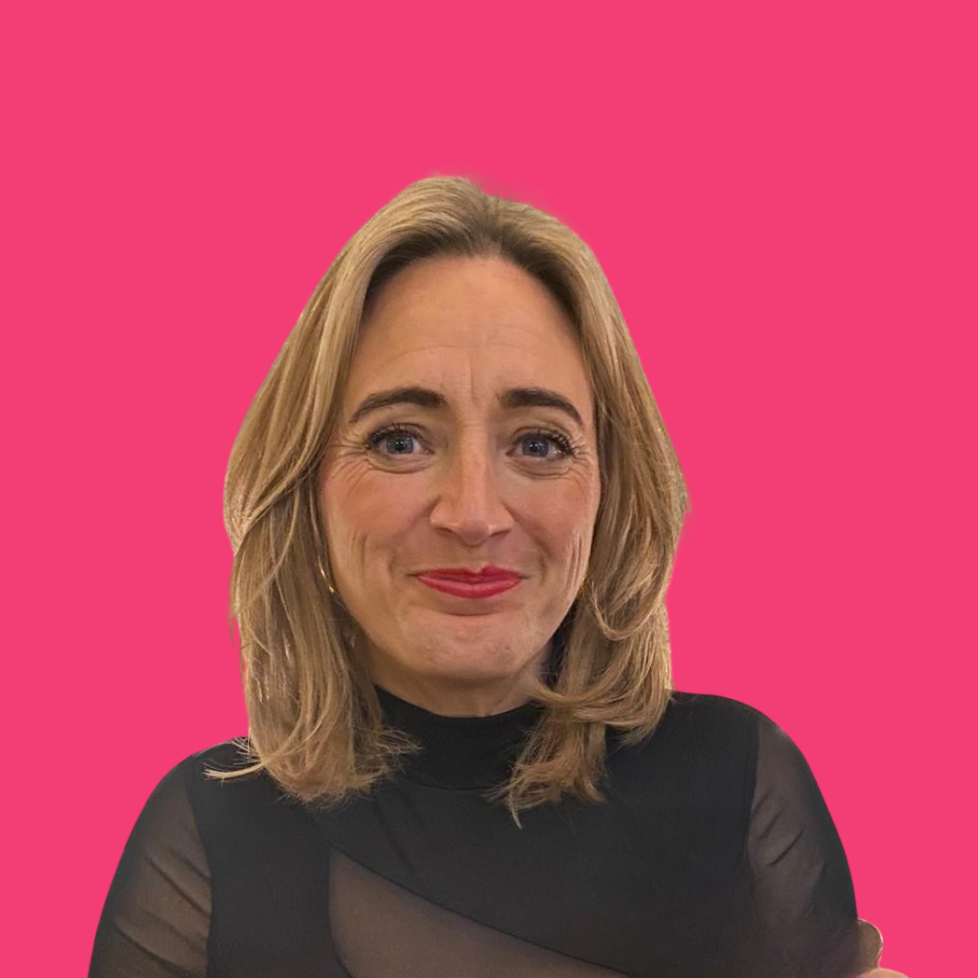 Woman with blonde hair wearing a black top, smiles against a bright pink background.