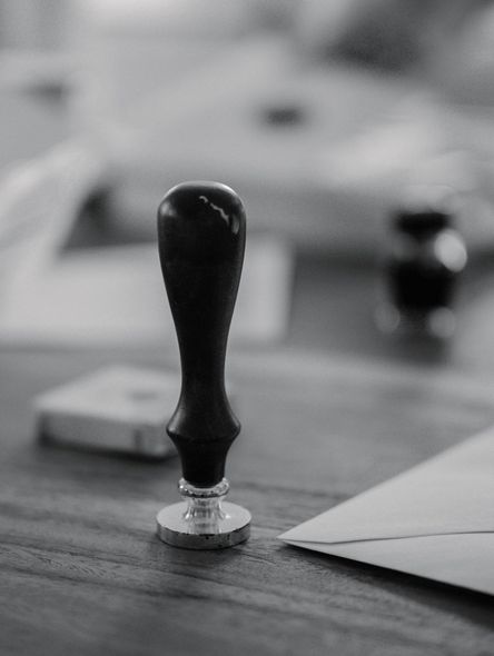 Black chess pawn on a wooden board, with blurred game pieces in the background