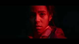 Close-up of a person’s face lit by intense red light in a dark scene