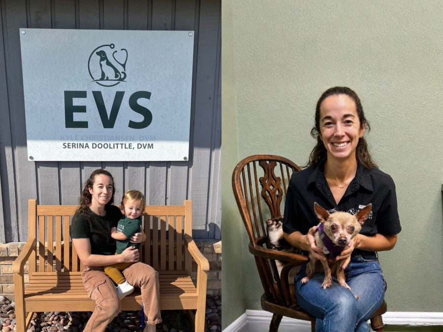 EVS sign beside two people seated on wooden chairs holding small dogs, indoor setting