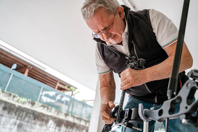 A man is fixing a camera on a tripod.
