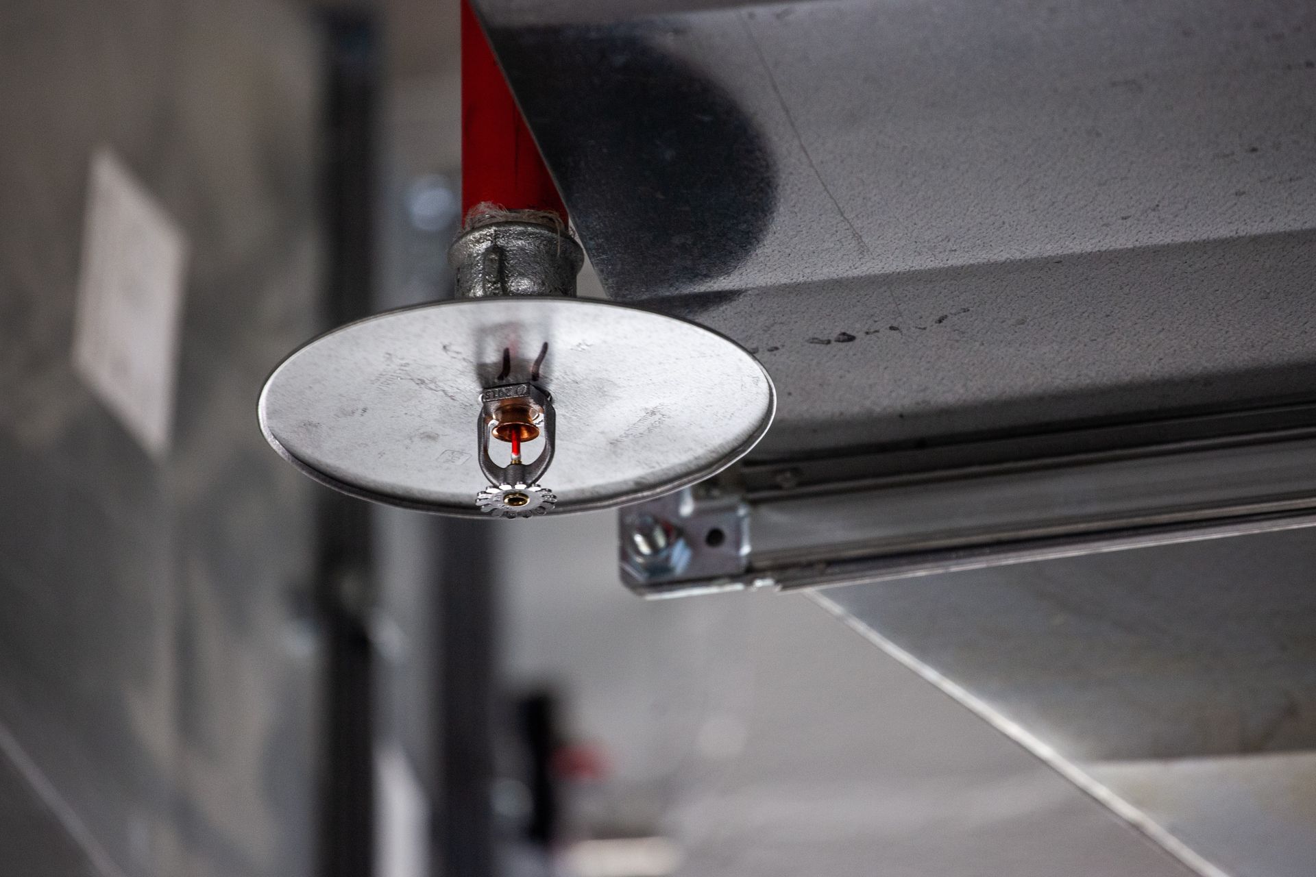 Close-up of a garage door track and roller bracket with a red cable Close-up of a garage door track and roller bracket with a red cable