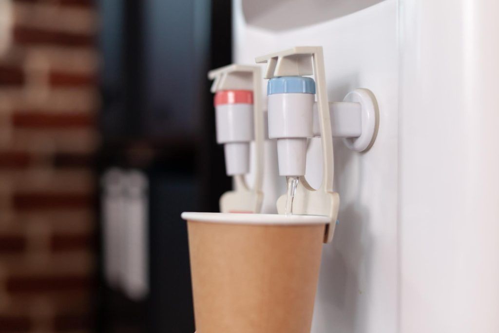 Paper Cup Being Filled With Water From a Water Cooler — Vantage Plumbing and Drainage In Pacific Pines, QLD